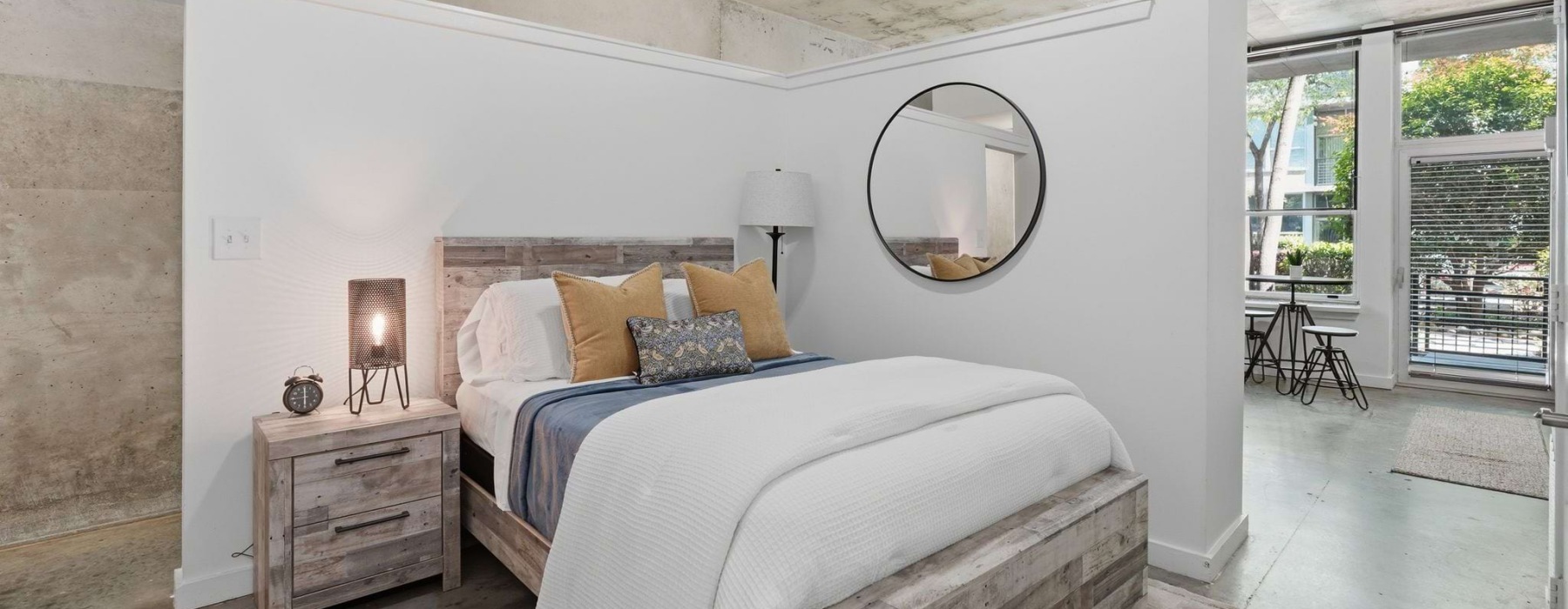 Bedroom with wood accent wall and private balcony in a 2 bedroom apartment at 1016 Lofts, West Midtown Atlanta